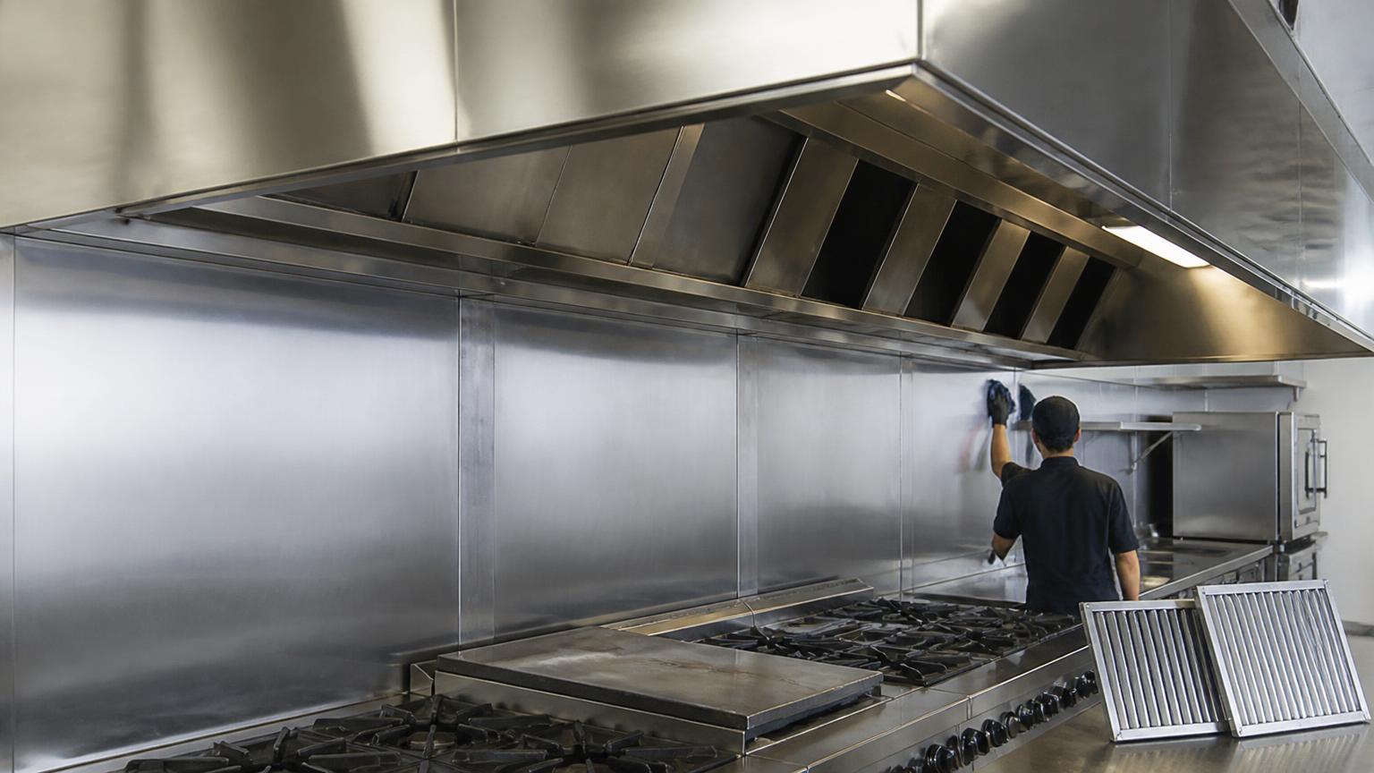 Hotte en acier inoxydable et filtres d'une cuisine commerciale pendant un dégraissage